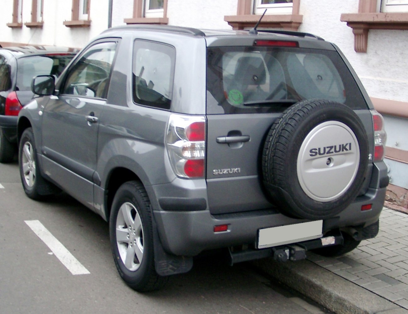 Rear view of SUV with mounted spare tire and roof rails