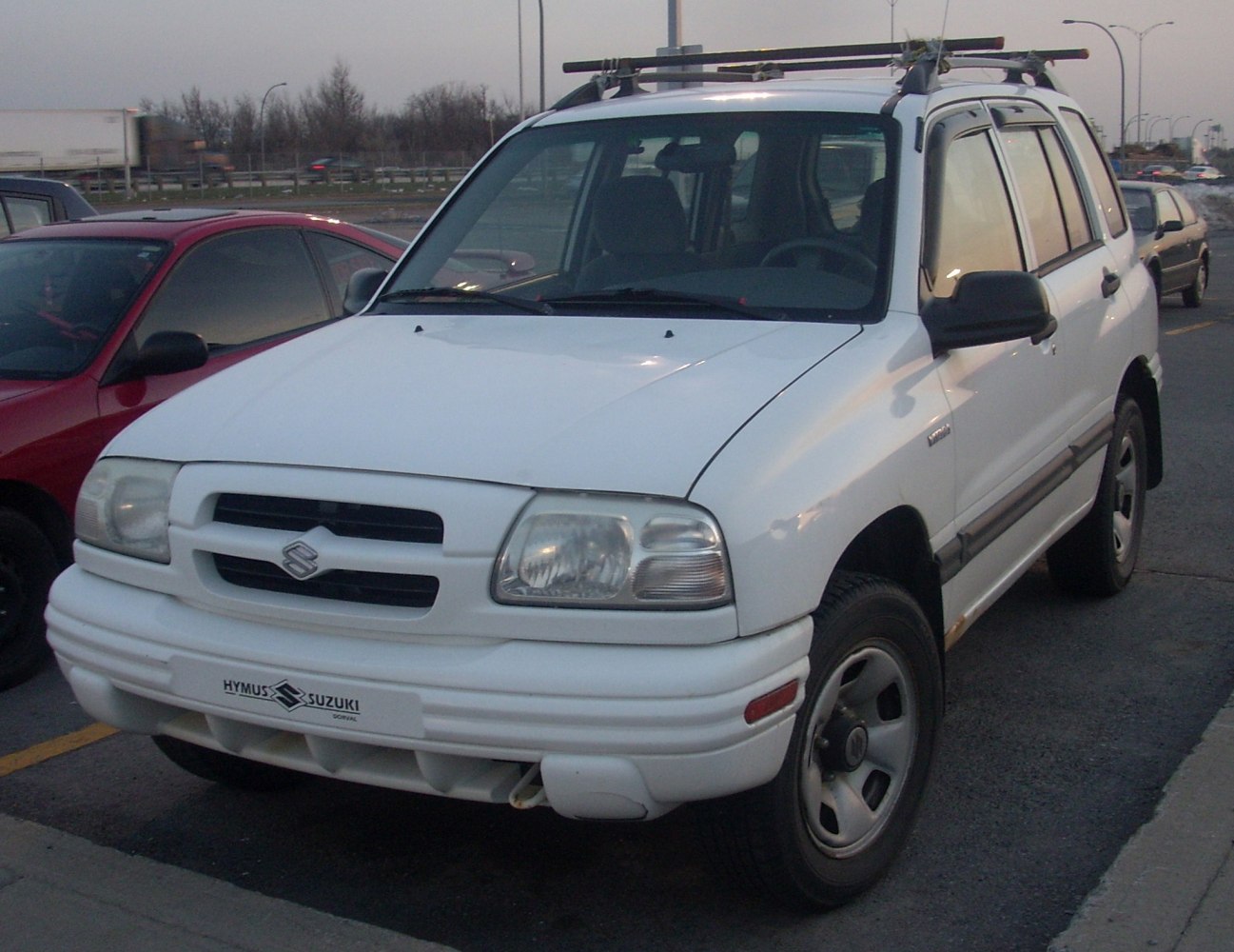 White SUV with roof rack and distinctive grille design