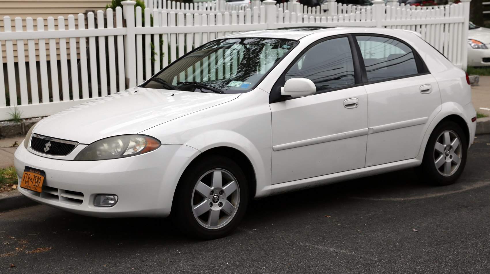 White compact sedan with alloy wheels and front fog lights
