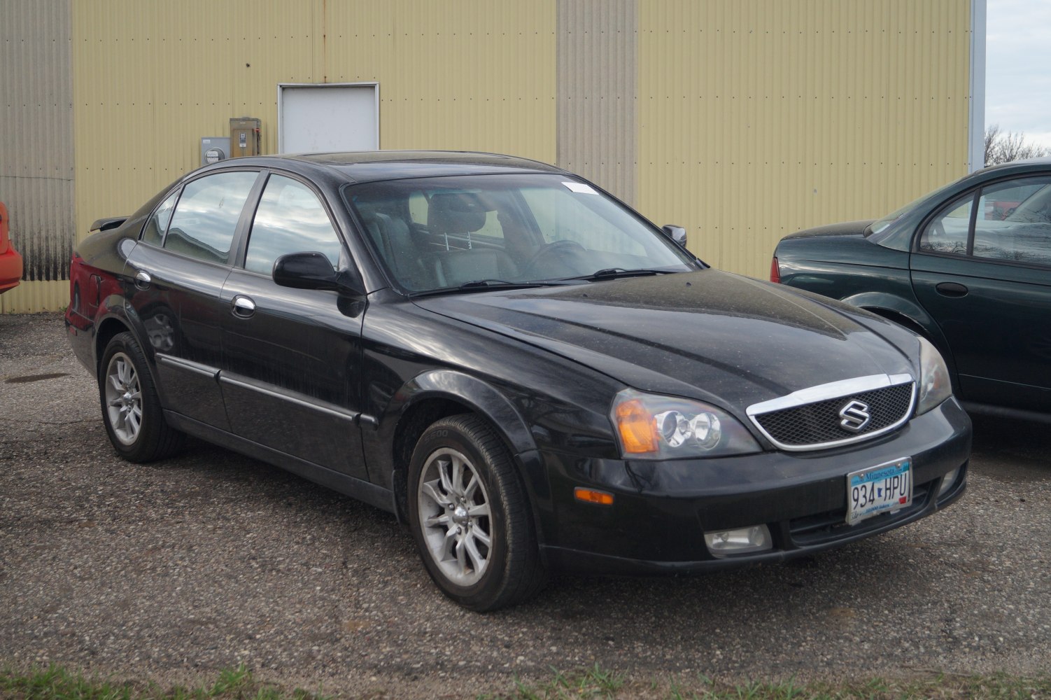 Black sedan front side view with distinctive grille and headlights