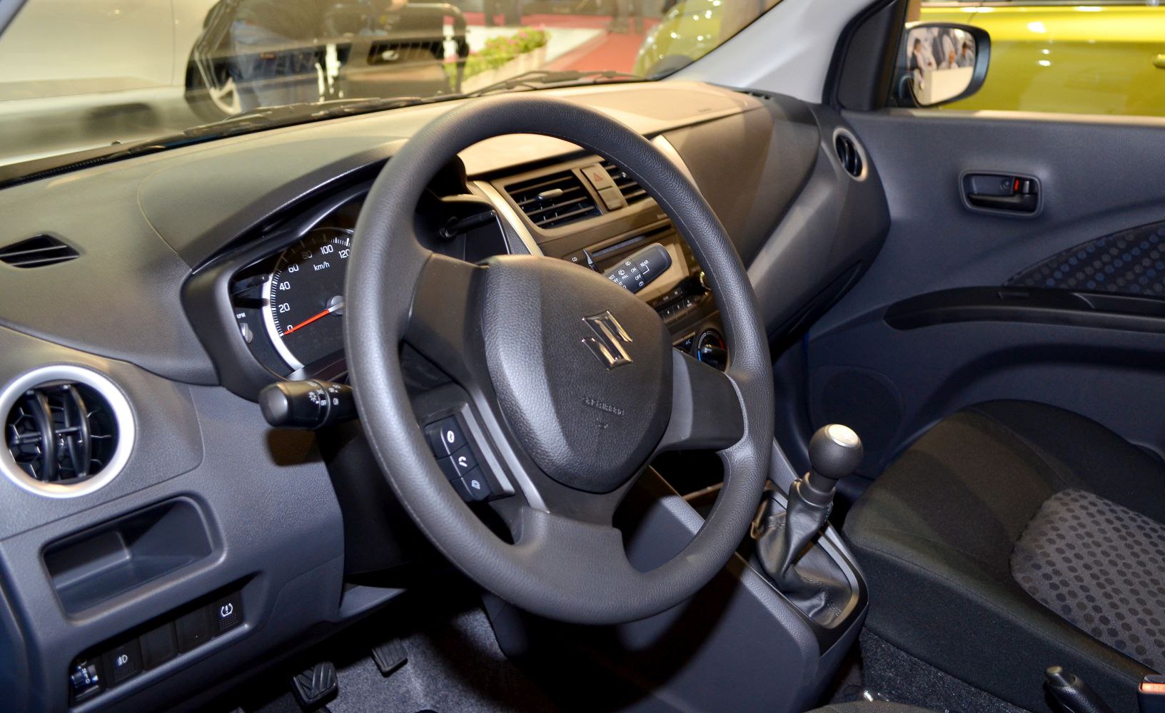 Steering wheel, dashboard with speedometer, manual gear stick interior.