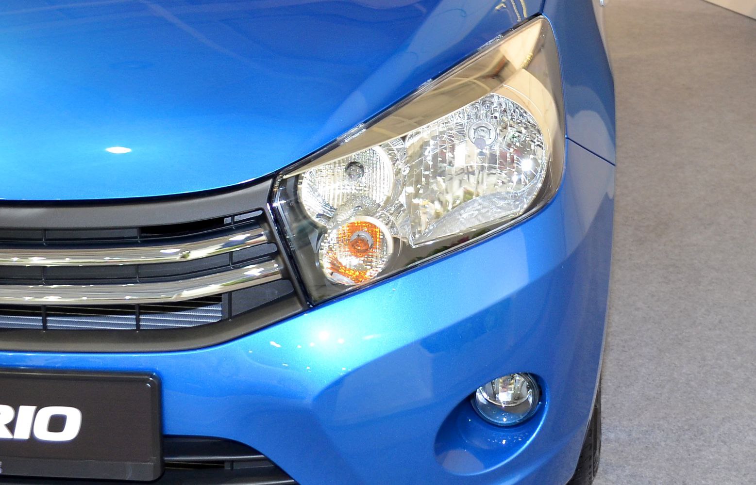 Close-up of front headlight assembly and adjacent grille with fog light