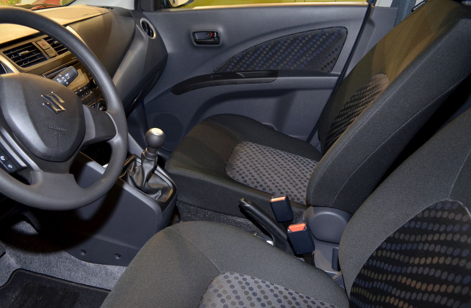 Interior view with manual gearshift, dashboard, and patterned seats