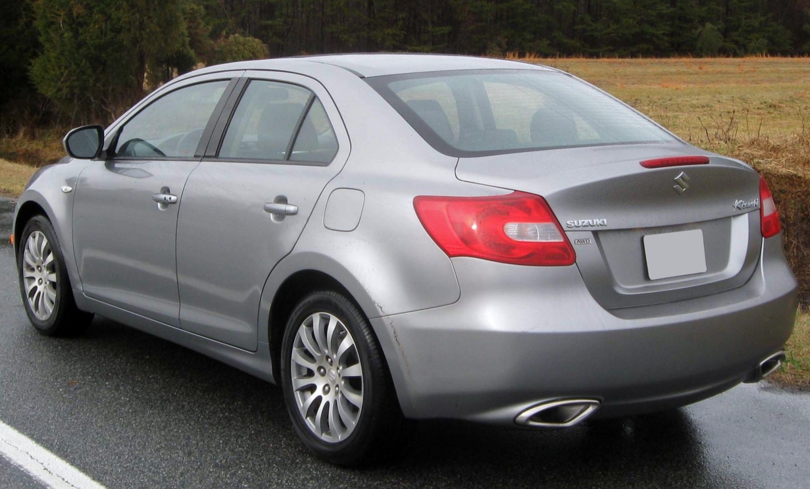 Silver mid-size sedan rear-side view with dual exhaust and alloy wheels