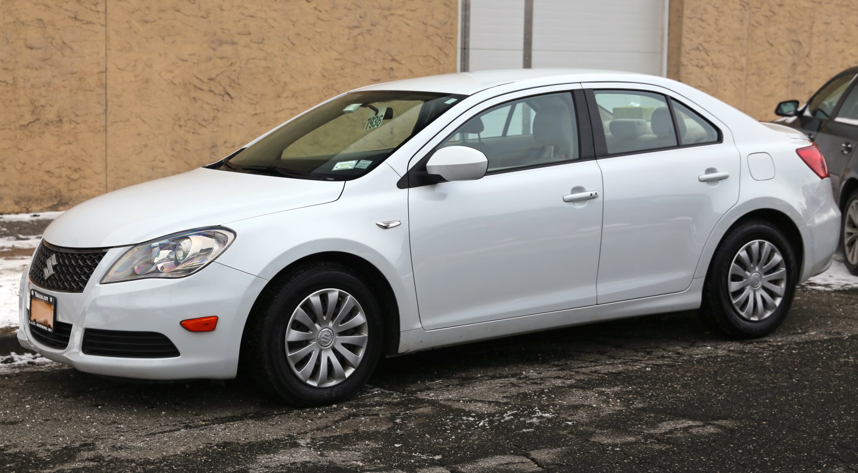 White mid-size sedan side view with alloy wheels and aerodynamic design