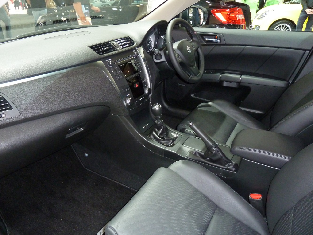 Car interior with dashboard, manual gearshift, and black seats