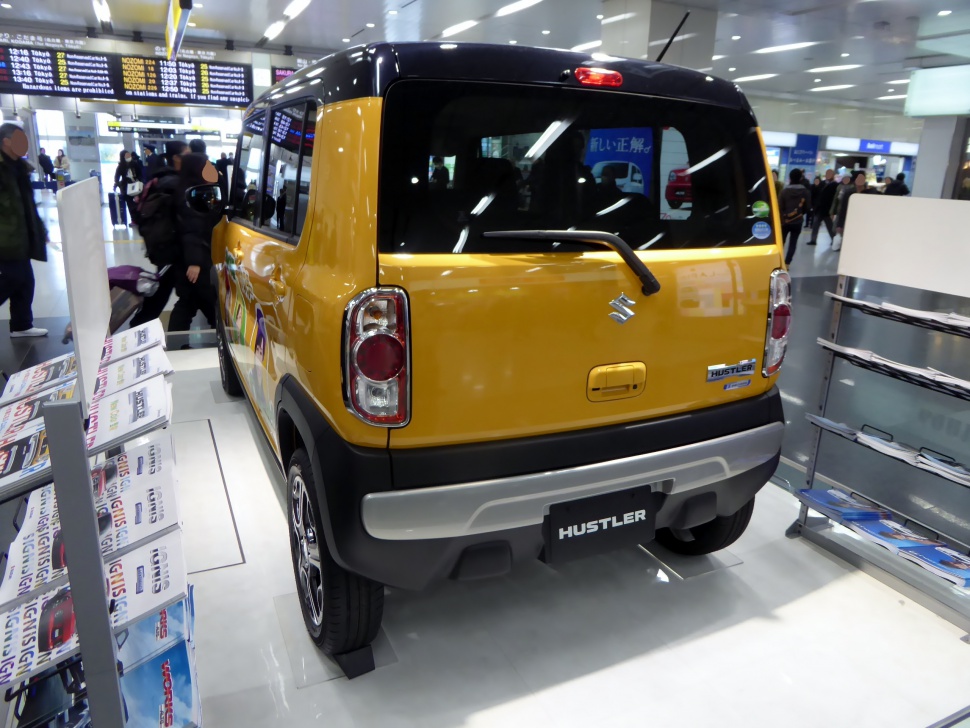 Compact vehicle rear with distinctive tail lights and two-tone paint.