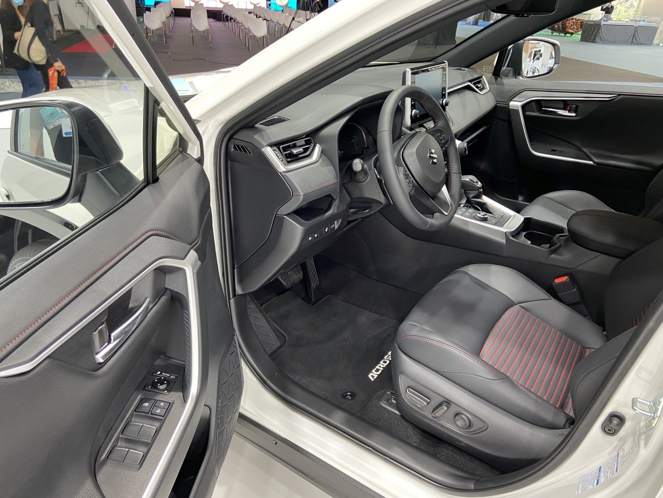 Modern car interior with dashboard, steering wheel, and leather front seats.