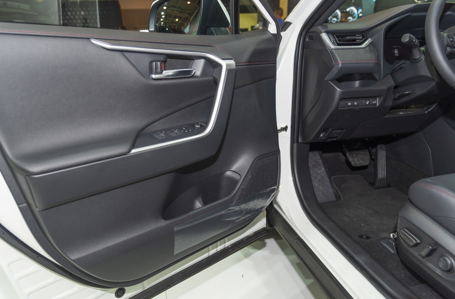 Interior door panel with controls and driver footwell area