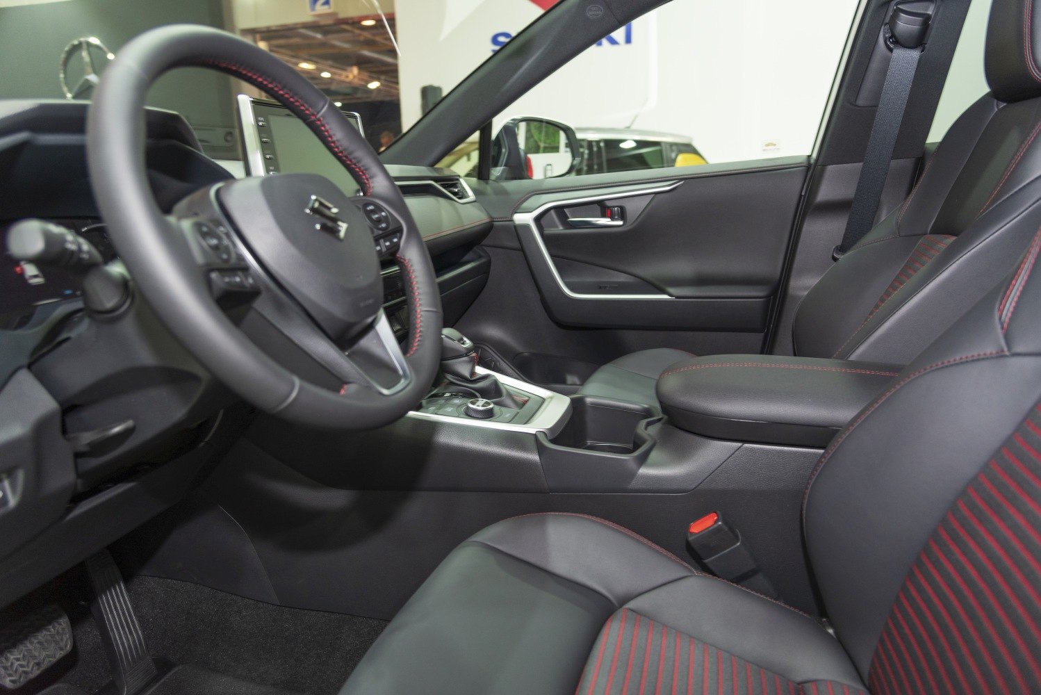 Leather seats with red stitching and multifunction steering wheel in car interior