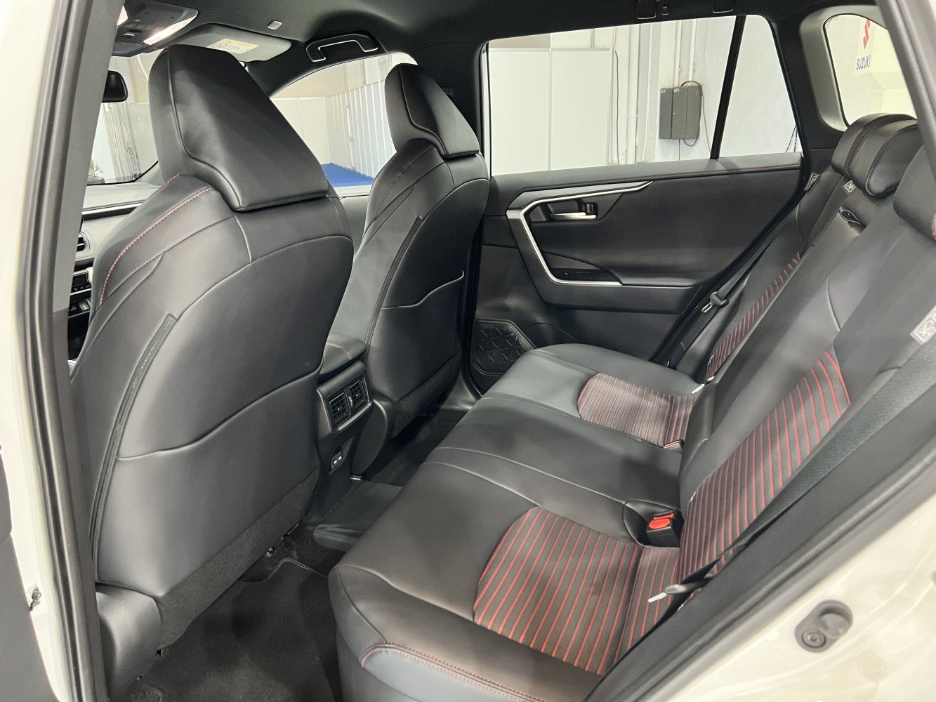 Rear interior black leather seats with red stitching and spacious layout