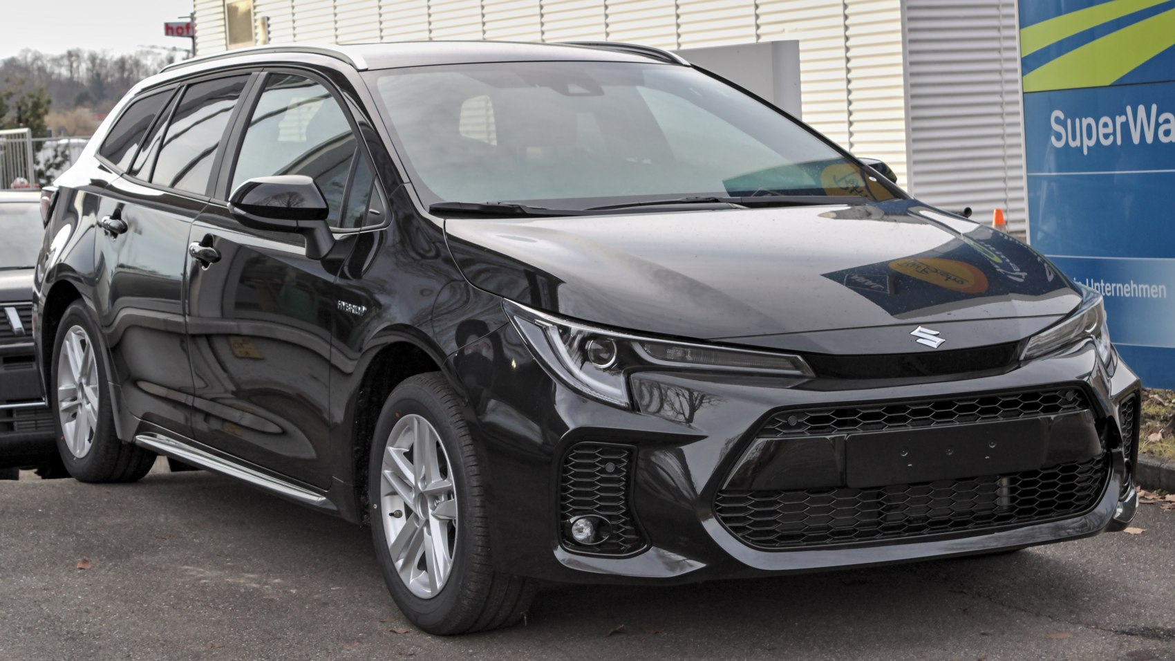 Front side view of a modern sleek wagon with sharp headlights and honeycomb grille