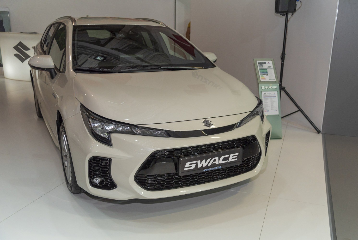 Front view of car with sleek headlights and large black grille