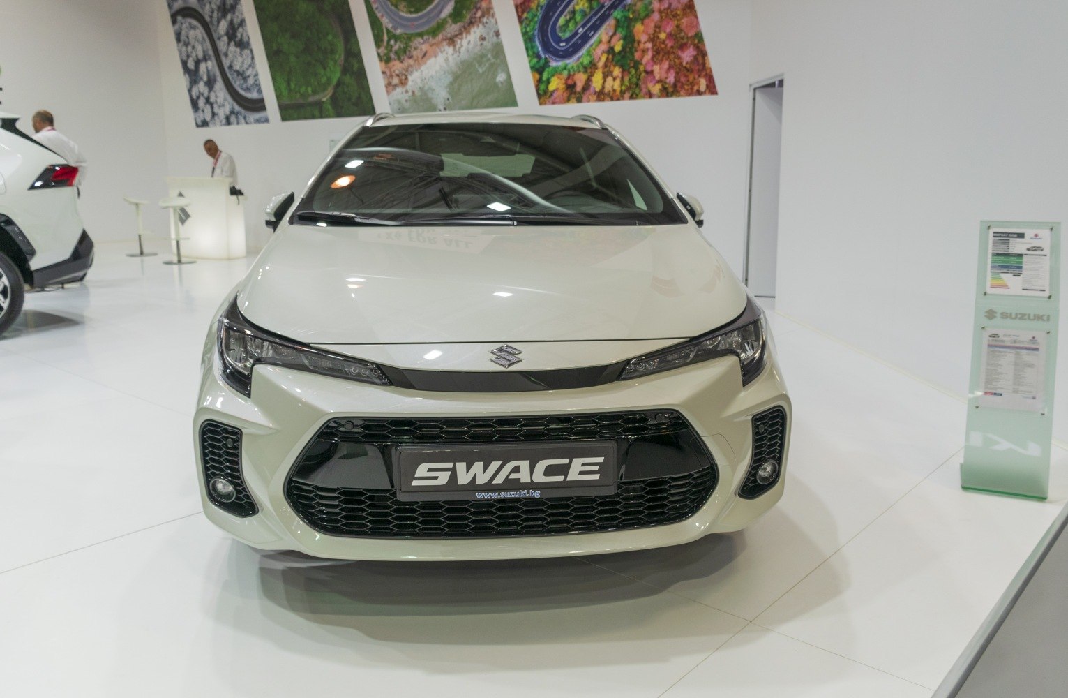 Front view of a hatchback with sleek headlights and large black honeycomb grille