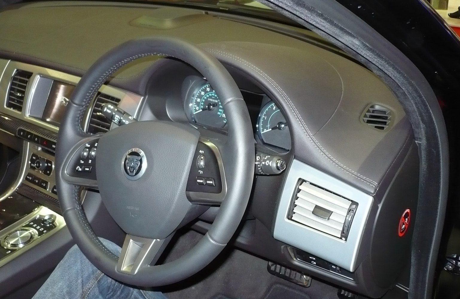 Luxury car interior with steering wheel, dashboard, and gear selector