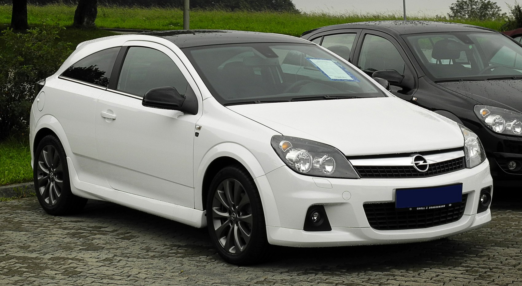 White hatchback with sporty design and alloy wheels front side view