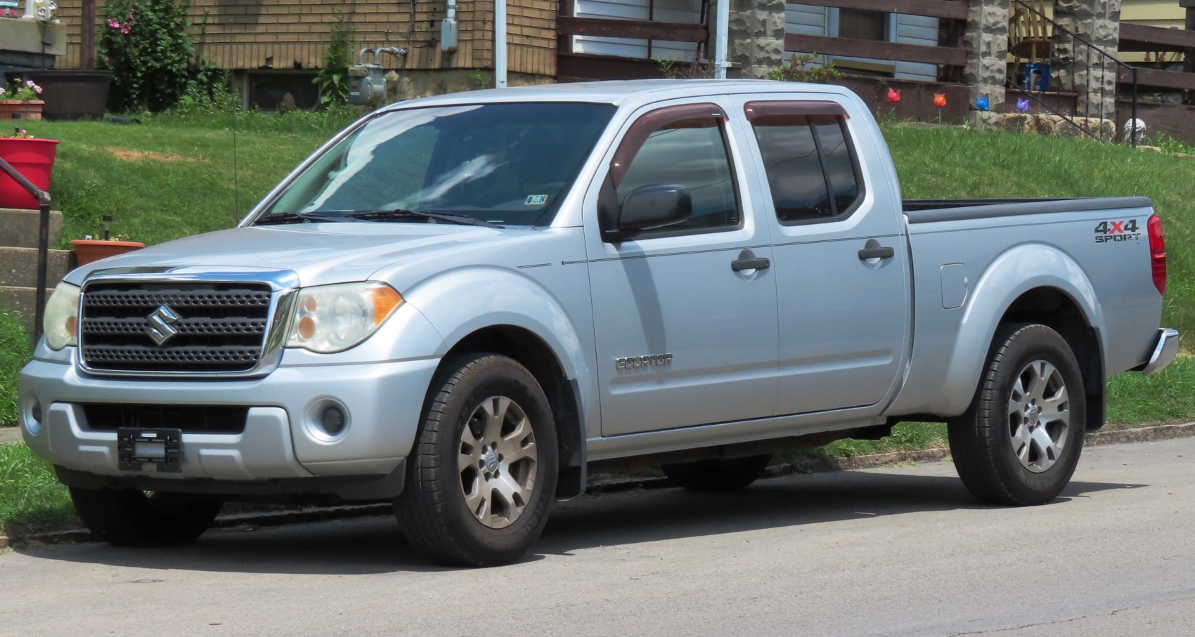 Silver crew cab pickup with extended cab and long bed, 4x4 sport emblem.