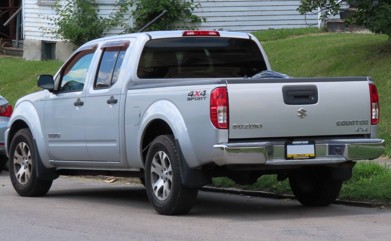 Rear and side view of silver extended bed 4x4 sport pickup.