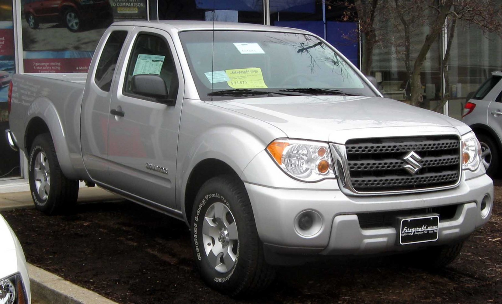 Front corner view of extended cab pickup with headlight and grille