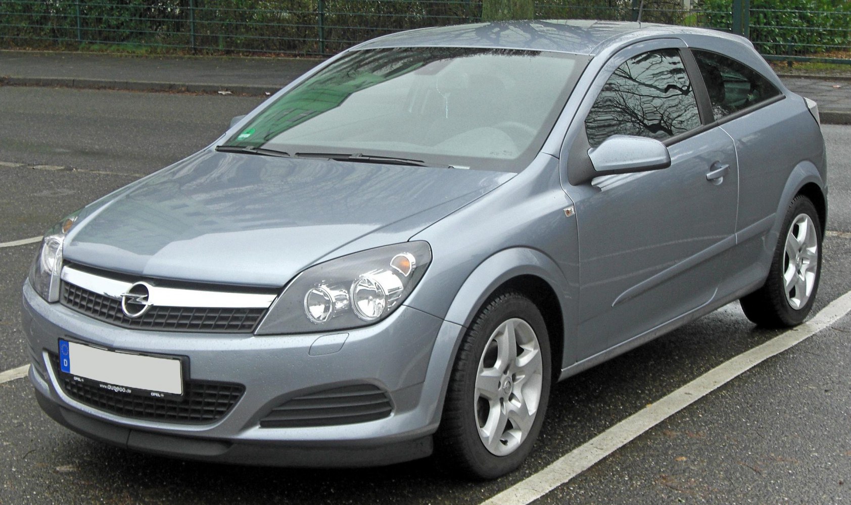 Front and side view of a hatchback featuring dual headlights and aerodynamic body.