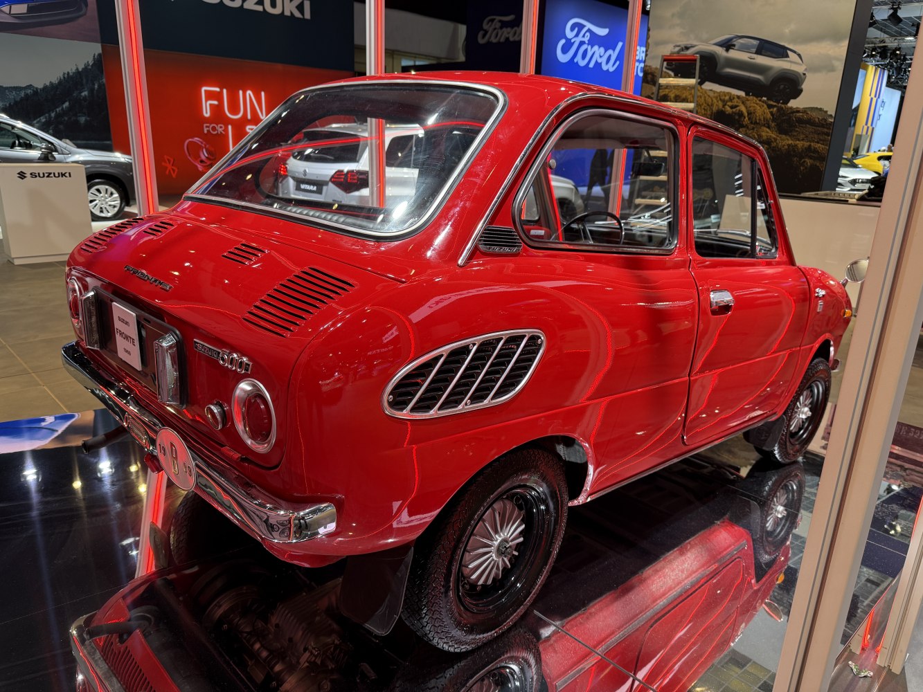 Bright red classic compact car with rear and side air vents.
