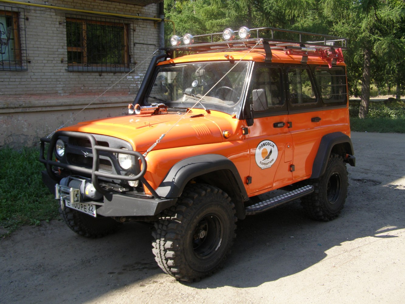 Off-road SUV with roof rack, winch, rugged tires, and extra lighting