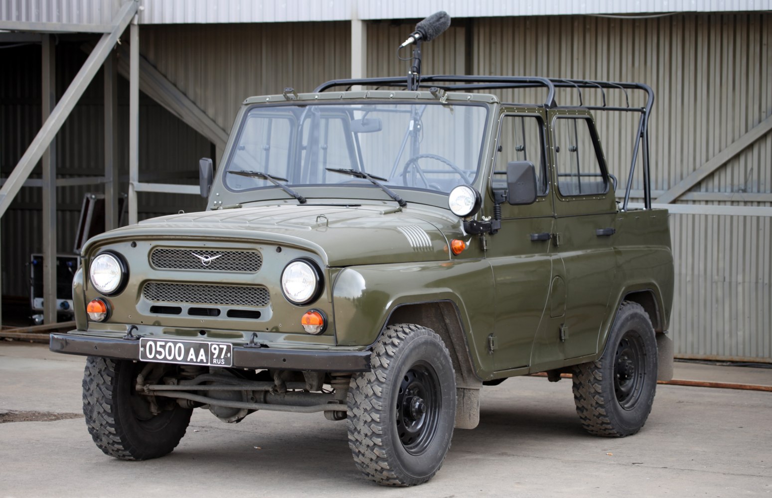 Military-style off-road SUV with rugged tires and roll cage