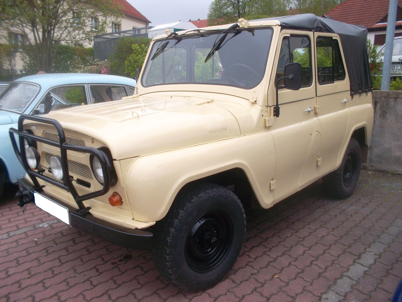 Beige off-road vehicle with front grille guard and canvas roof