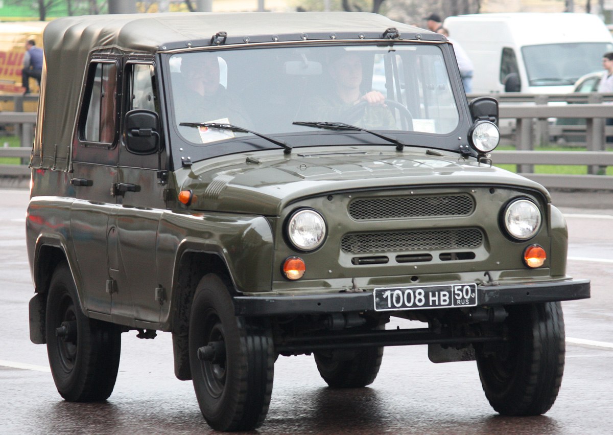 Off-road vehicle with canvas soft top and round headlights.