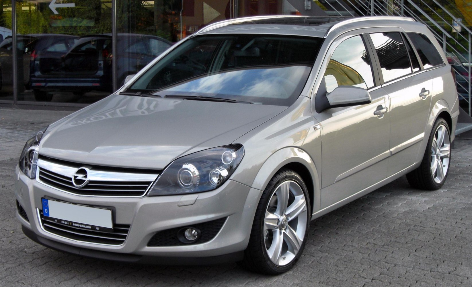 Front-side view of a station wagon with headlights and alloy wheels