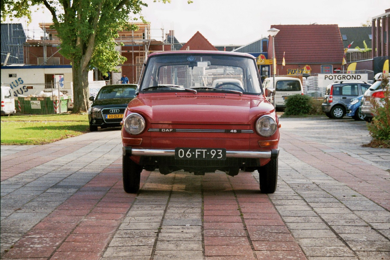 Front view of a compact classic car with round headlights and vintage styling.