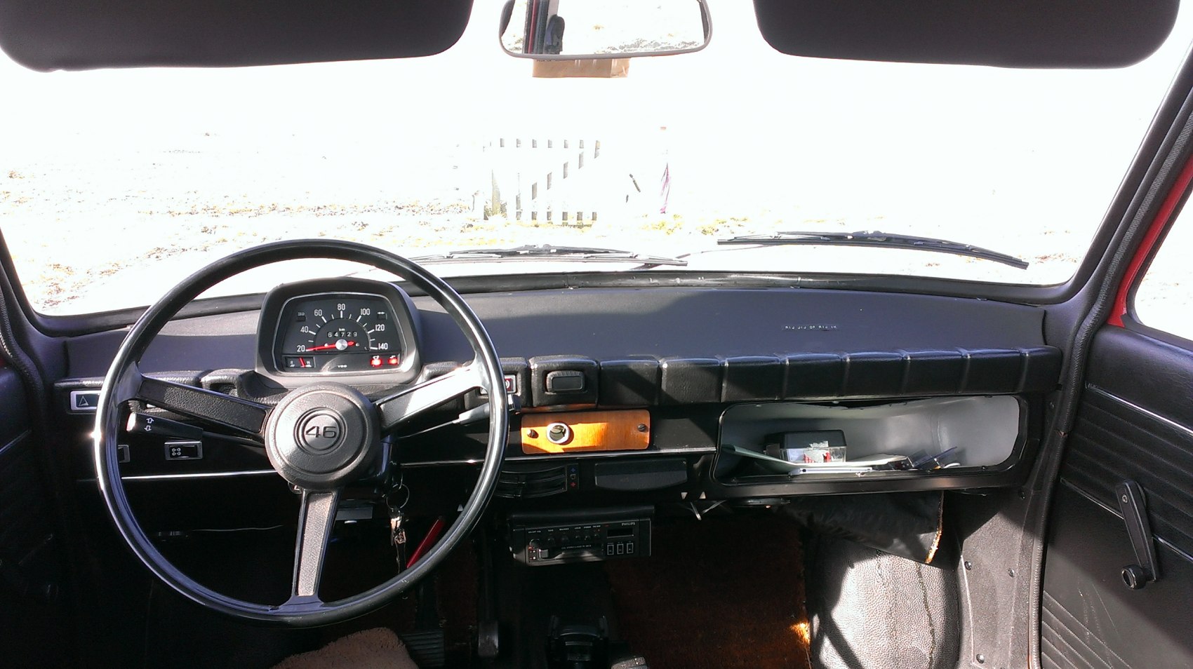 Vintage 1970s steering wheel and dashboard with classic speedometer.
