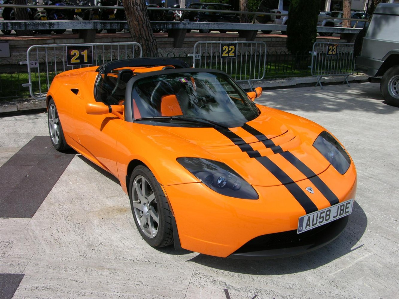 Bright orange electric convertible with black racing stripes