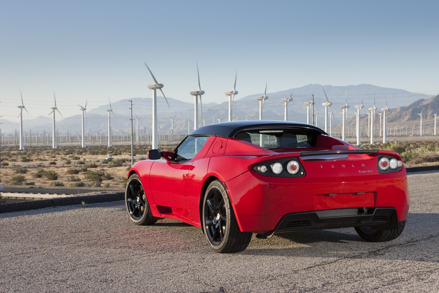 Red electric sports coupe rear with black wheels and distinctive tail lights.