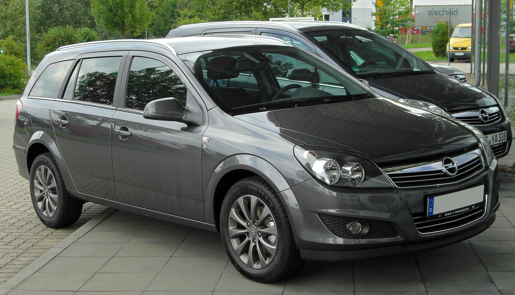 Gray station wagon front-side view with detailed headlights and alloy wheels
