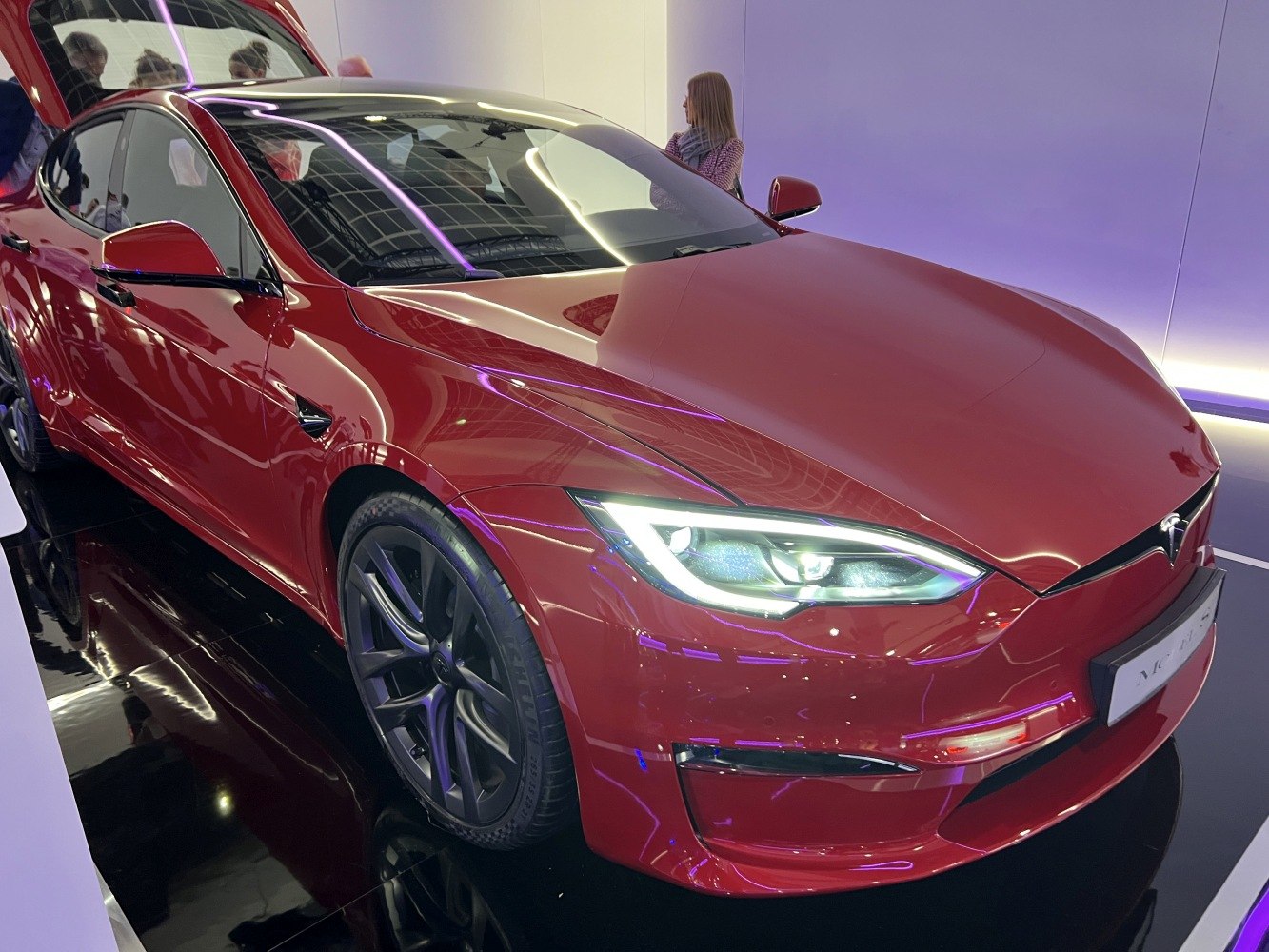 Red electric sedan with sharp LED headlights and aerodynamic design