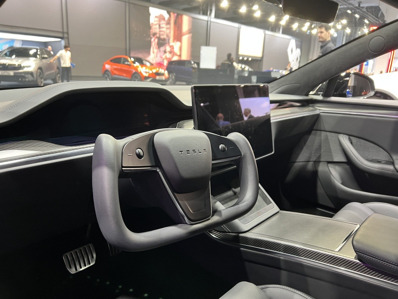 Yoke steering wheel and large central touchscreen inside modern electric vehicle