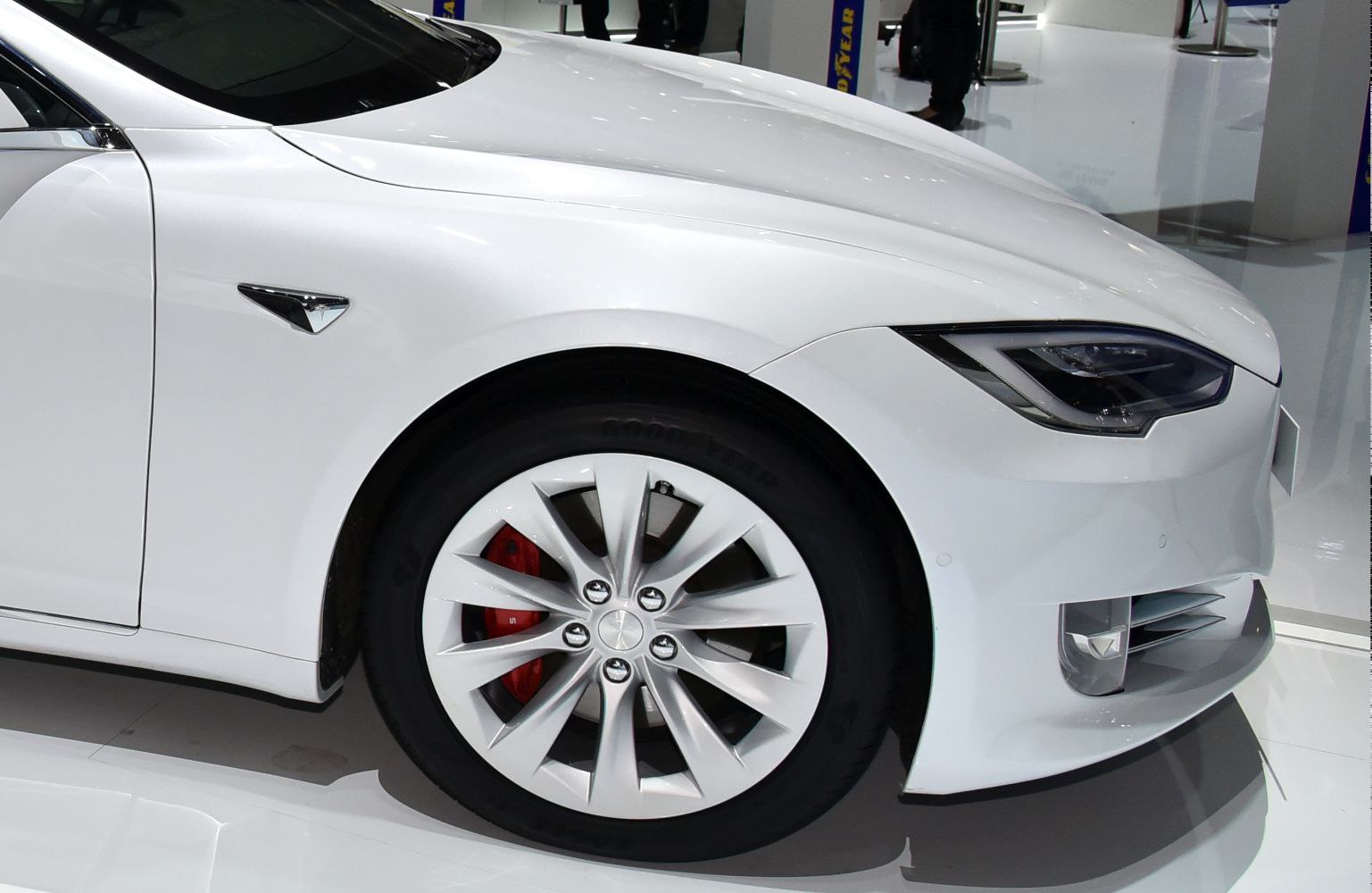 Front wheel with alloy rim, red brake caliper, and sleek headlight