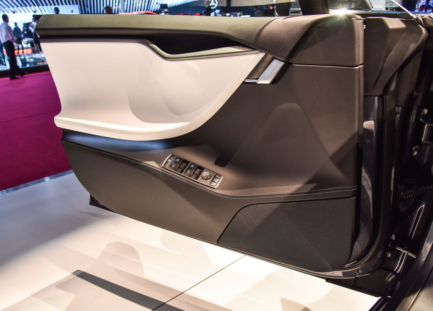 Two-tone interior door panel with electronic controls and speaker.
