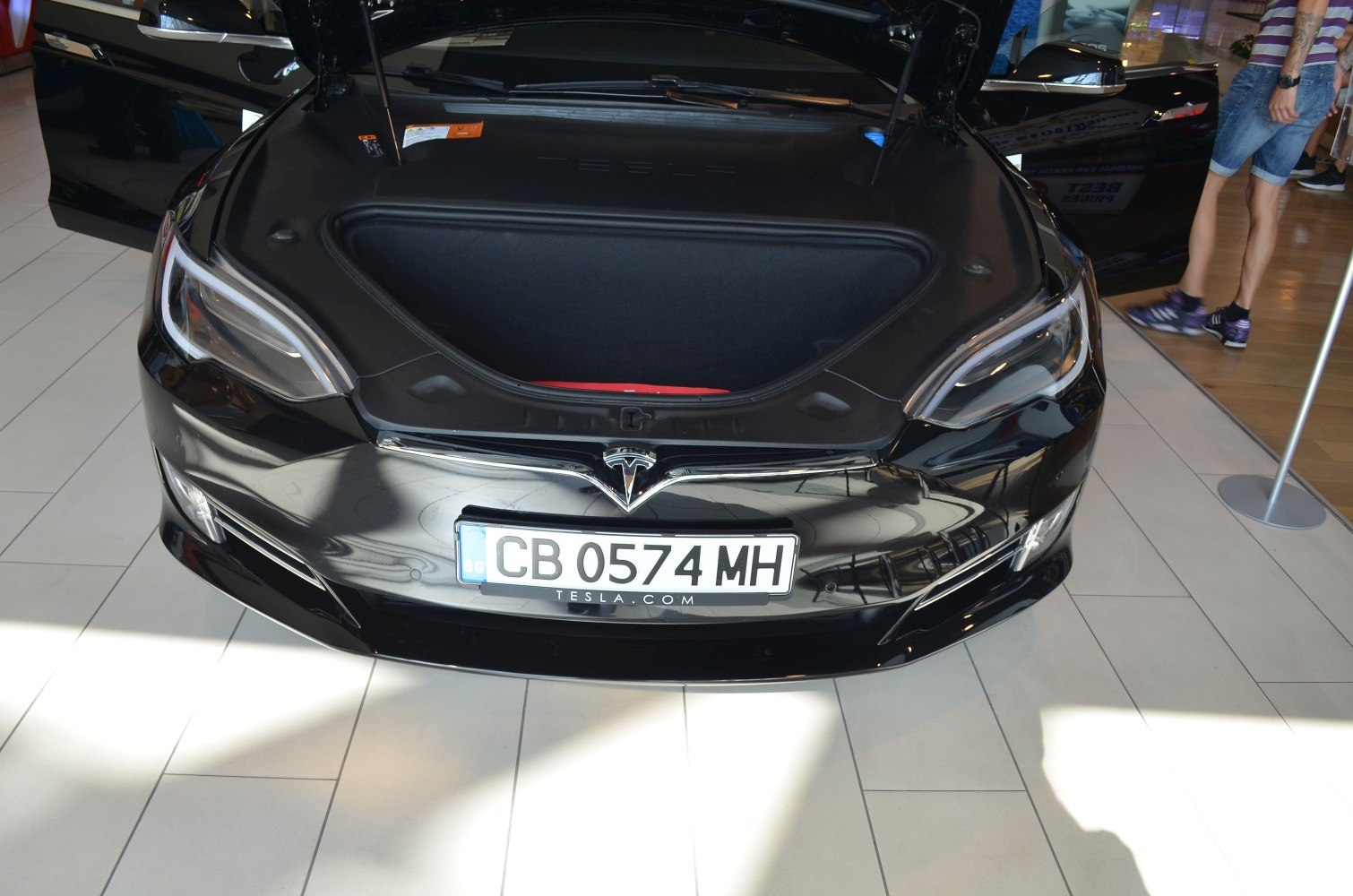 Open front trunk and headlights of black electric vehicle