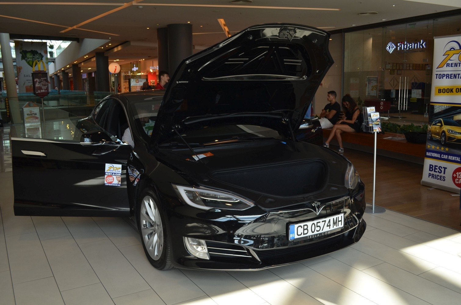 Open front trunk of an electric sedan in an indoor environment