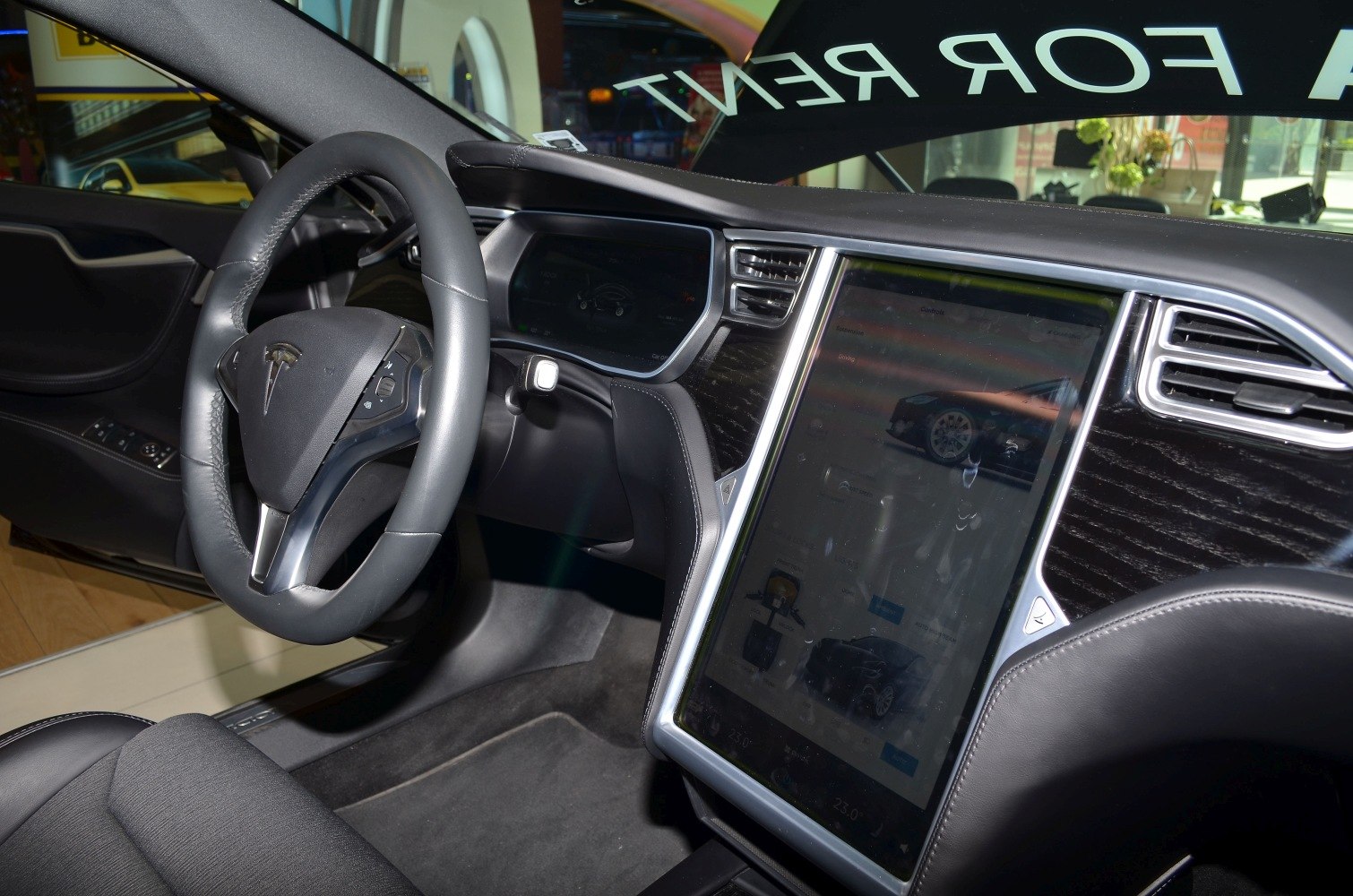 Tesla interior with large vertical touchscreen and digital instrument cluster