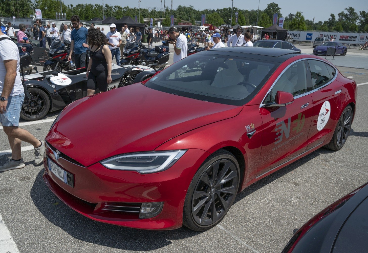 Red executive sedan with sleek LED headlights and sporty alloy wheels.