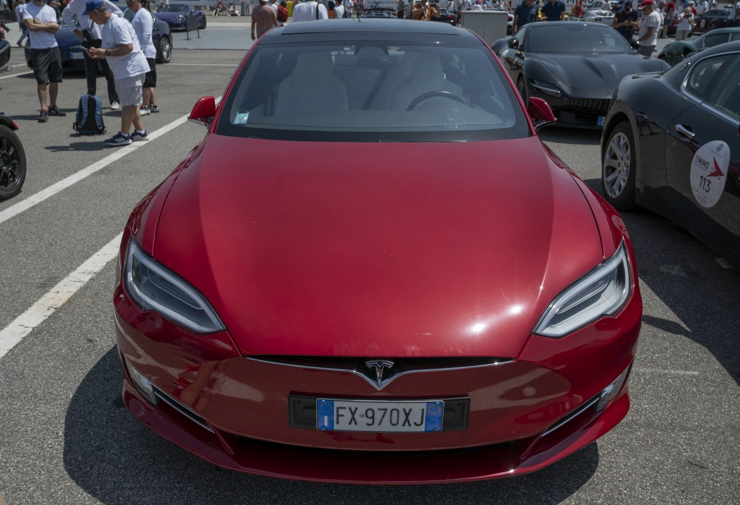 Red electric vehicle front view with sleek headlights and aerodynamic design