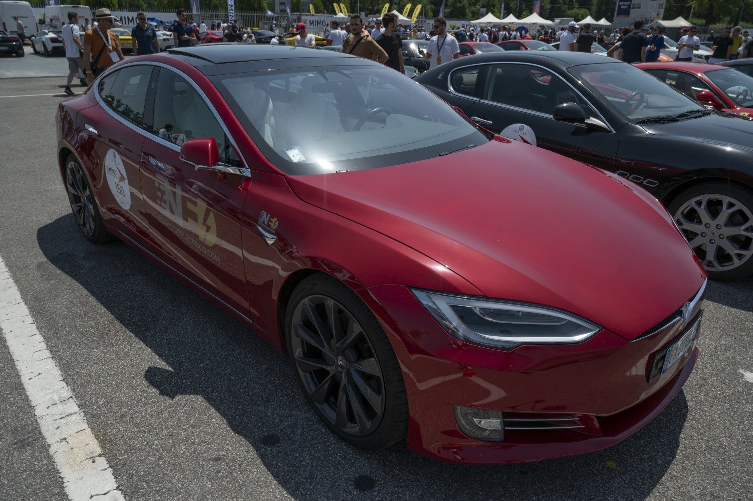 Red electric sedan with LED headlights and black alloy wheels