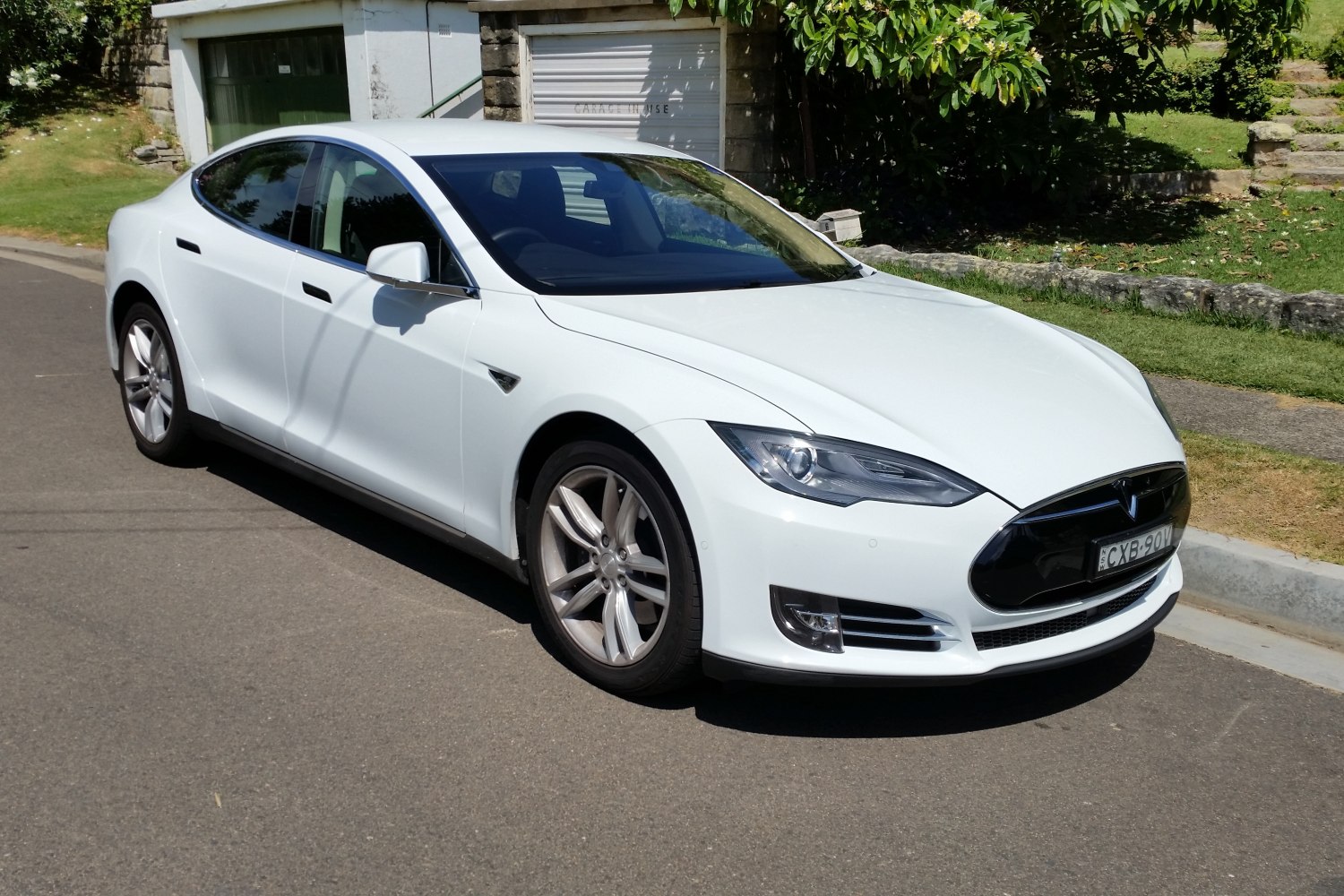 White electric sedan front side with sleek design and alloy wheels