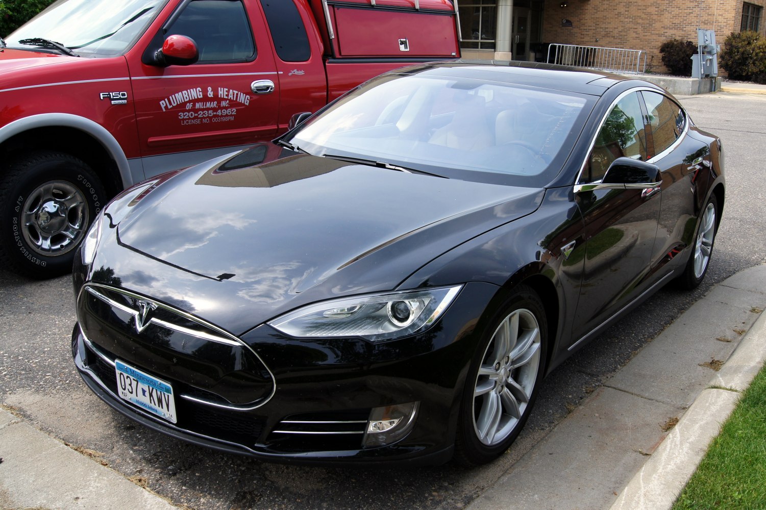 Black electric luxury sedan with aerodynamic body and sharp headlights