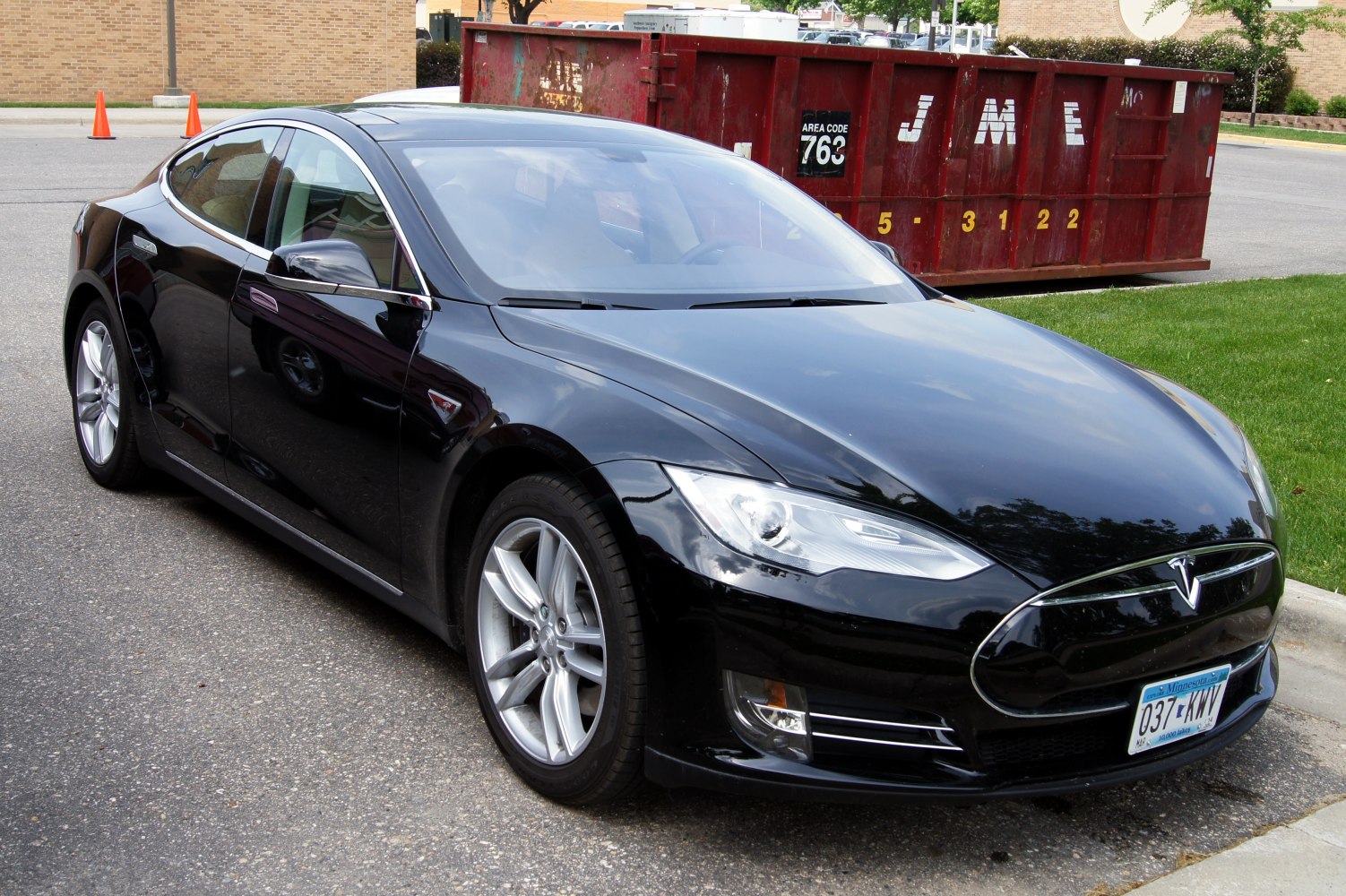 Front and side profile of a black electric sedan with aerodynamic design and alloy wheels