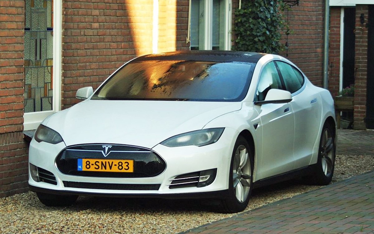 Front view of white electric sedan with sleek headlights and grille