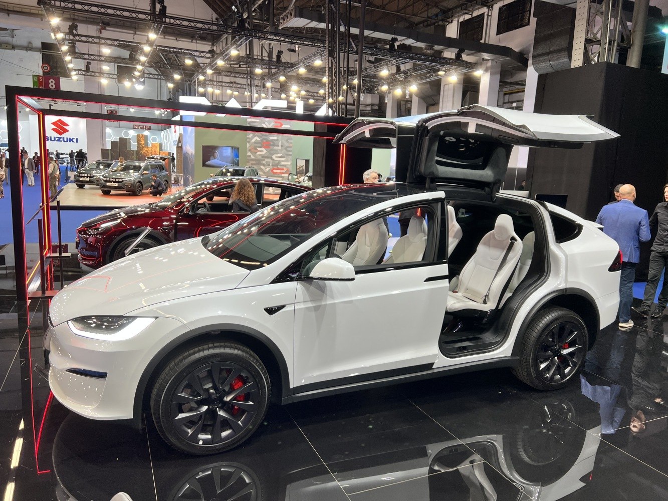 Falcon wing doors open with white interior seats and black wheels